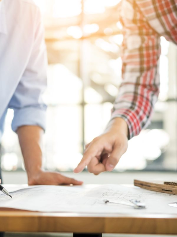 Close-up,Of,Person's,Engineer,Hand,Drawing,Plan,On,Blue,Print